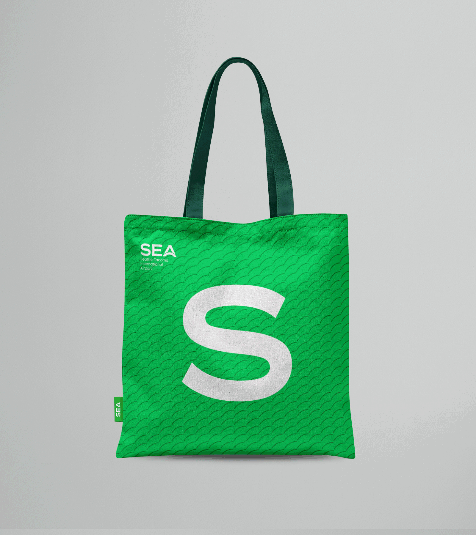 Animation of an SEA branded tote bag switching green and white color themes each featuring one of the letters 'SEA'.